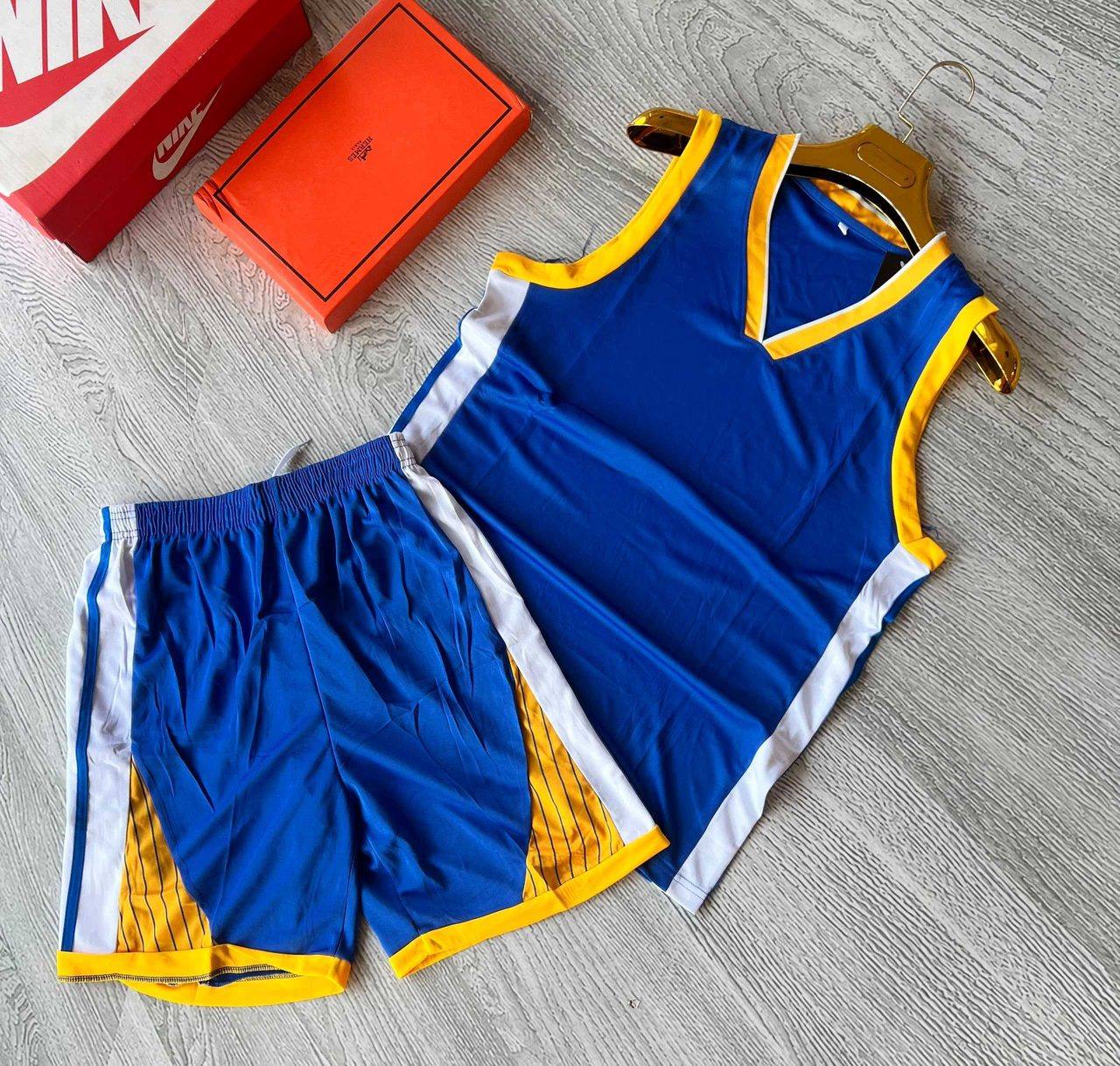 A blue sleeveless sports jersey and shorts set with gold and white trim, unbranded and ready for team logos