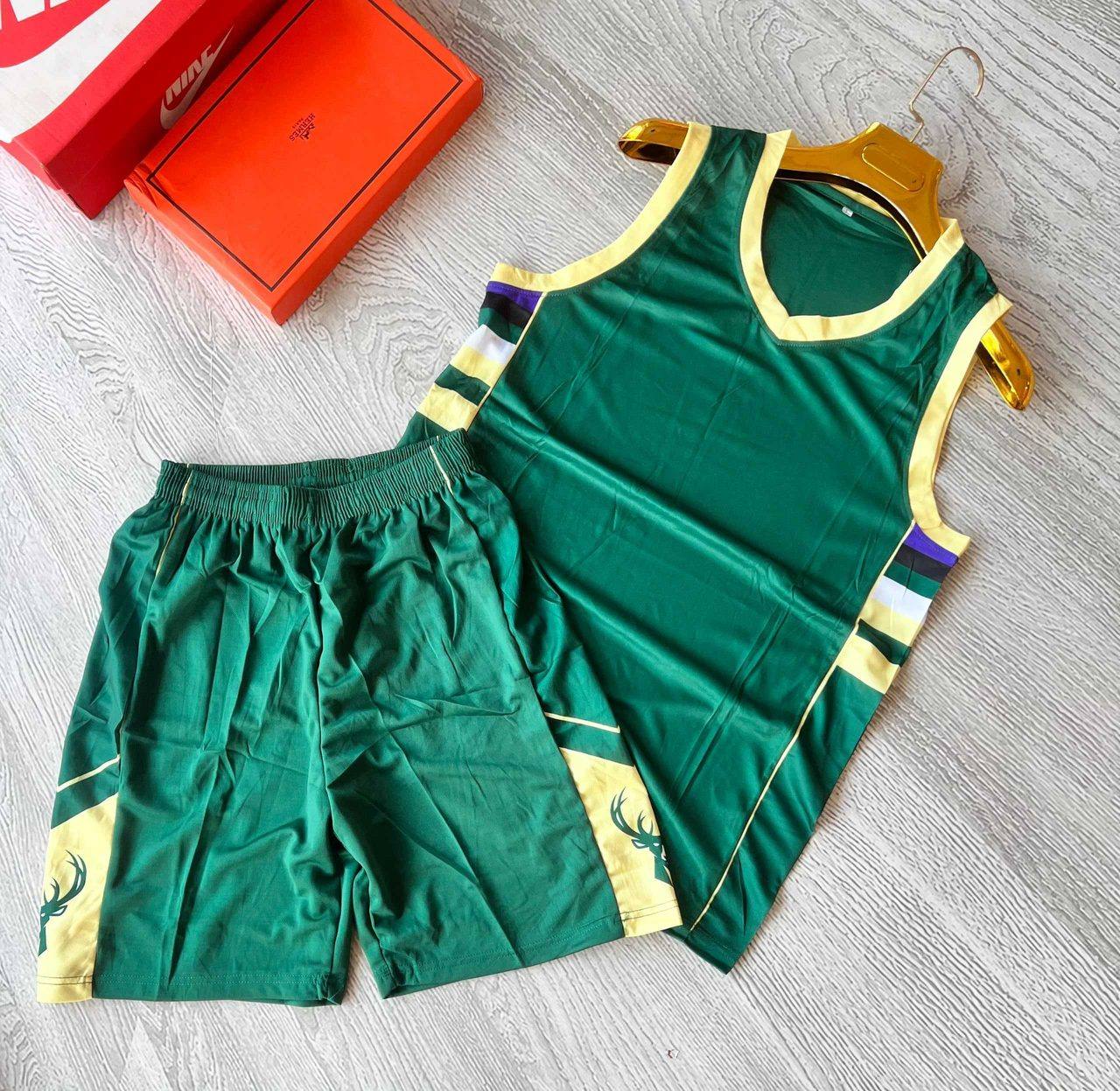 A green sleeveless sports jersey and shorts set with gold trim, unbranded and ready for team logos